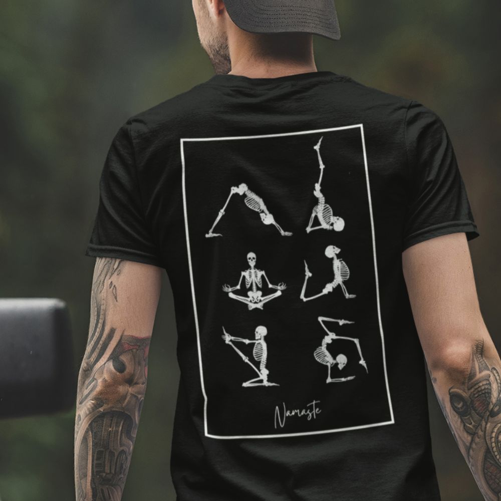 Homme portant T-shirt noir avec squelettes drôles en posture de yoga imprimé sur le dos, coton bio vu de dos.