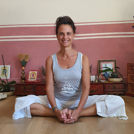 Cécile Taric portant le débardeur yoga en gris chiné avec le symbole du feu production éco-responsable de sa collection pour femme
