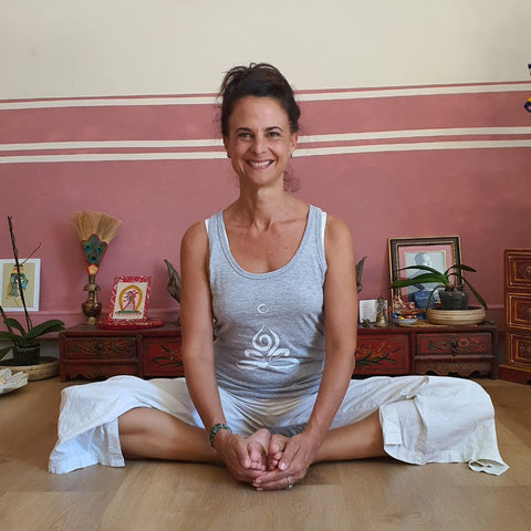 Cécile Taric portant le débardeur yoga en gris chiné avec le symbole du feu production éco-responsable de sa collection pour femme